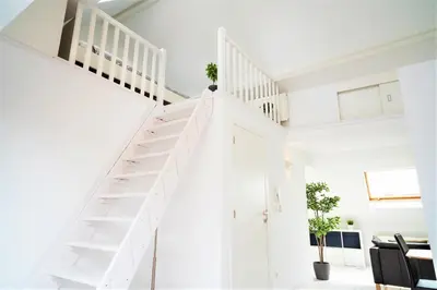 a white staircase in a living room with white walls at Beautiful Terrace Apartment in the Heart of Antwerp in Antwerp
