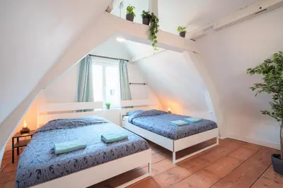 a attic bedroom with two beds and a window at Antwerp Old Town Centrum Apartment in Antwerp
