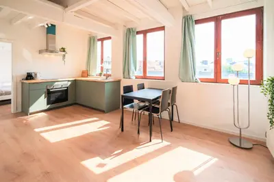 a kitchen with a table and chairs in a room at Saint Pauls Central Residence in Antwerp