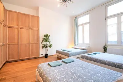 two beds in a room with two windows at Saint Pauls Central Residence in Antwerp