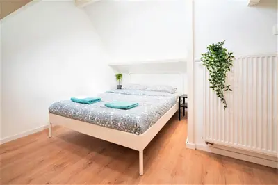 a bedroom with a bed with blue pillows on it at Saint Pauls Central Residence in Antwerp