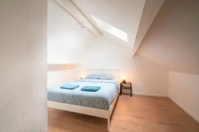a bedroom with a bed with blue pillows on it at Saint Pauls Central Residence in Antwerp