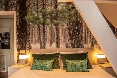 a bedroom with a bed with a large painting on the wall at Beautiful city center apartments in Ghent near medieval castle in Ghent