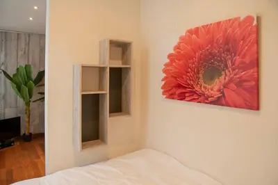 a bedroom with a painting of a flower on the wall at Beautiful city center apartments in Ghent near medieval castle in Ghent