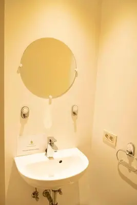 a bathroom with a white sink and a mirror at Beautiful city center apartments in Ghent near medieval castle in Ghent