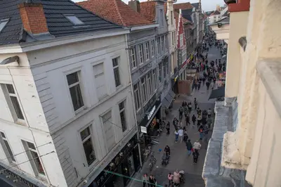 a group of people walking down a city street at Beautiful city center apartments in Ghent near medieval castle in Ghent
