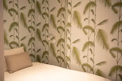 a bedroom with a bed with a tropical wallpaper at Beautiful city center apartments in Ghent near medieval castle in Ghent