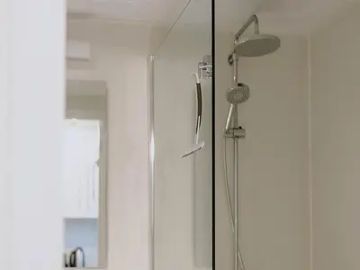 a shower in a bathroom with a shower head at Geel Chalet in Netevallei in Geel