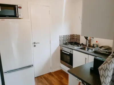 a kitchen with a white refrigerator and a sink at Geel Chalet in Netevallei in Geel
