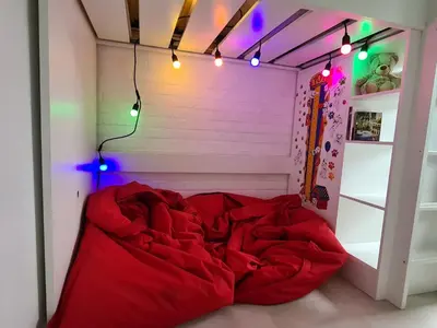 a red bed in a room with lights on it at Rent & Relax in Mol