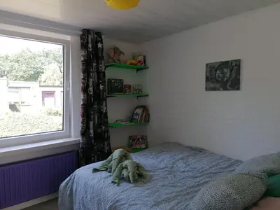 a dog laying on a bed in a bedroom at Rent & Relax in Mol