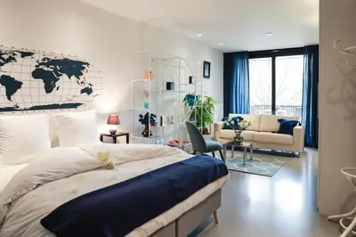 a bedroom with a large bed and a living room at Suite Aux Anges in Antwerp