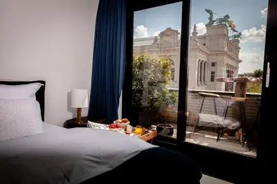 a bedroom with a bed and a window with a building at Suite Aux Anges in Antwerp