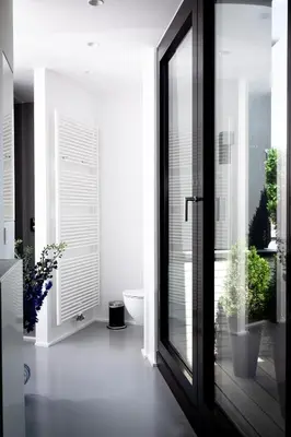 a bathroom with a large glass door with potted plants at Suite Aux Anges in Antwerp