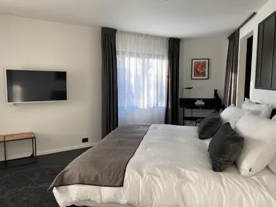 a hotel room with a bed and a flat screen tv at B&B Miranoza in Oud-Heverlee