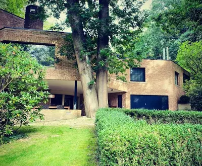 a brick house with a tree in front of it at B&B Miranoza in Oud-Heverlee