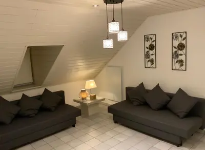 a living room with two couches and a staircase at LinZn vakantiehuis in Wuustwezel