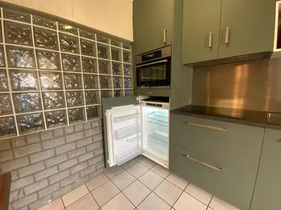 a kitchen with green cabinets and an open refrigerator at LinZn vakantiehuis in Wuustwezel
