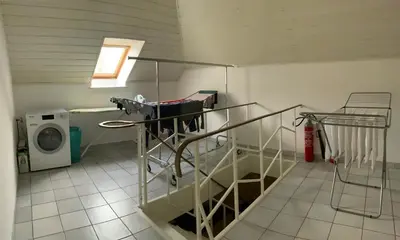 a laundry room with a staircase and a washing machine at LinZn vakantiehuis in Wuustwezel