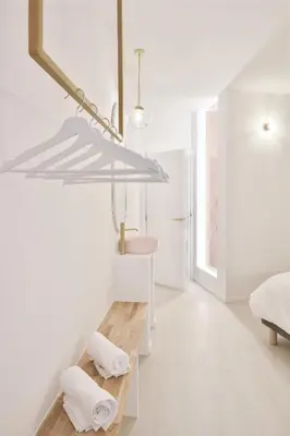 a white room with a bed and a table with towels at Urban Walls in Brussels