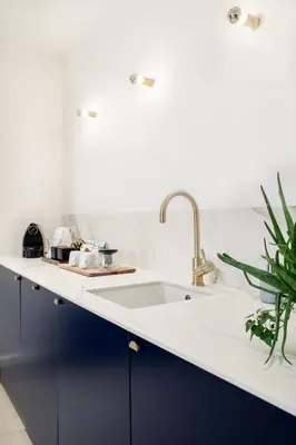a kitchen with blue cabinets and a sink at Urban Walls in Brussels