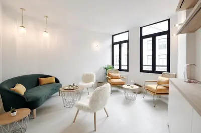 a living room with a green couch and chairs at Urban Walls in Brussels