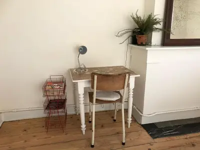 a desk with a lamp and a chair in a room at Logies Lapin in Antwerp