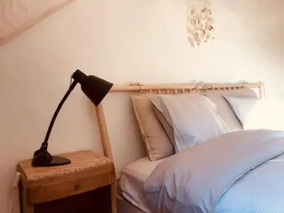 a black lamp on a table next to a bed at Logies Lapin in Antwerp