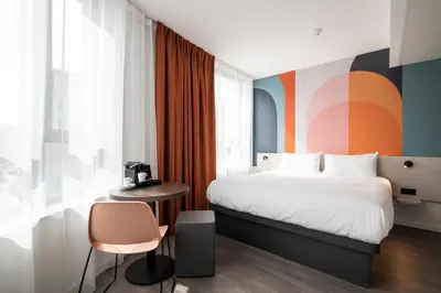a bedroom with a bed and a table and a chair at B&B HOTEL Antwerpen Centrum in Antwerp