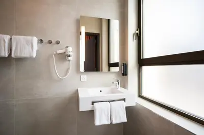 a bathroom with a white sink and a mirror at B&B HOTEL Antwerpen Centrum in Antwerp