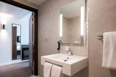 a bathroom with a white sink and a mirror at B&B HOTEL Antwerpen Centrum in Antwerp