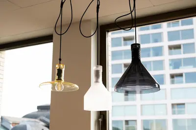 three lights hanging in a room with a window at B&B HOTEL Antwerpen Centrum in Antwerp