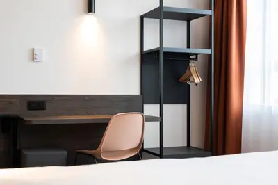 a bedroom with a desk and a chair next to a bed at B&B HOTEL Antwerpen Centrum in Antwerp