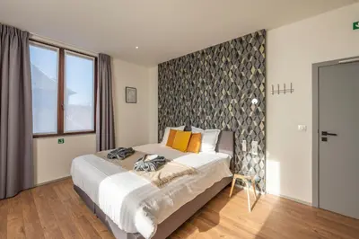 a bedroom with a large bed with orange pillows at Hotel Fi'Lin in Machelen
