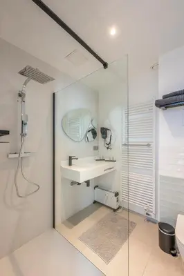 a bathroom with a sink and a shower at Hotel Fi'Lin in Machelen