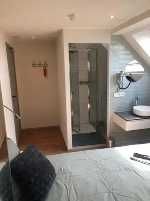 a bathroom with a shower and a bed and a sink at Hotel Fi'Lin in Machelen