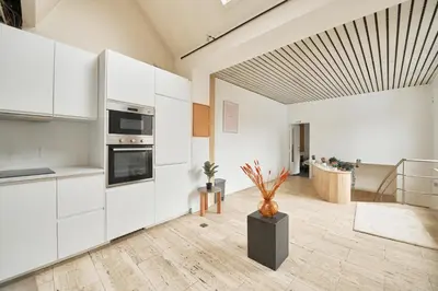 a kitchen with white cabinets and a vase on the floor at BoLofts in Antwerp