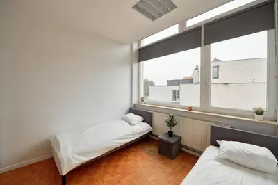 two beds in a room with a window at BoLofts in Antwerp