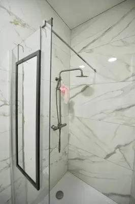 a shower with a glass door and a mirror at BoLofts in Antwerp
