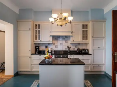 a kitchen with white cabinets and a chandelier at Villa Jasmine by Interhome in Mol
