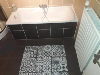 a bath tub with a black and white tile floor at Cosy Nest in Historical Center in Brussels