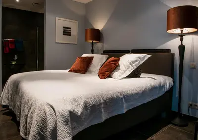 a bedroom with a bed with white sheets and pillows at Scheldeoever in Temse
