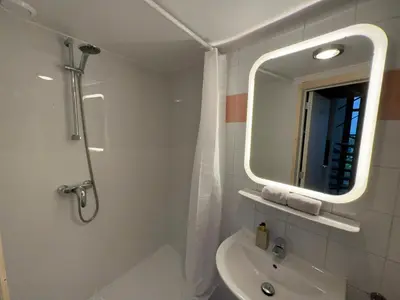 a bathroom with a shower and a sink and a mirror at Duplex in historical centre with private courtyard in Antwerp