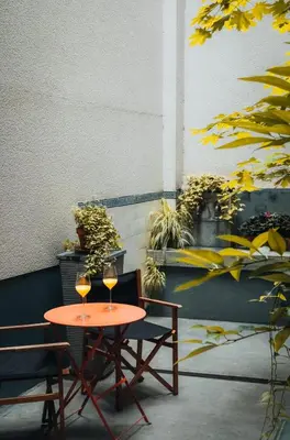 two glasses of wine sitting on a table with two chairs at Duplex in historical centre with private courtyard in Antwerp