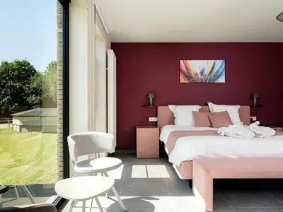 a bedroom with two beds and a red wall at b & b St-Hubert in Sint-Martens-Lennik