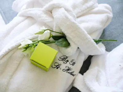 a white towel with flowers and a note on it at b & b St-Hubert in Sint-Martens-Lennik