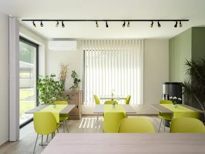a dining room with yellow chairs and tables at b & b St-Hubert in Sint-Martens-Lennik