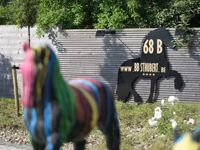 a toy horse in front of a sign with a dog at b & b St-Hubert in Sint-Martens-Lennik