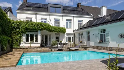a swimming pool in front of a house at B&B Tannerie in Balen