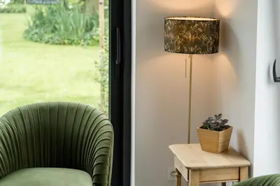 a living room with a green chair and a lamp at B&B Tannerie in Balen